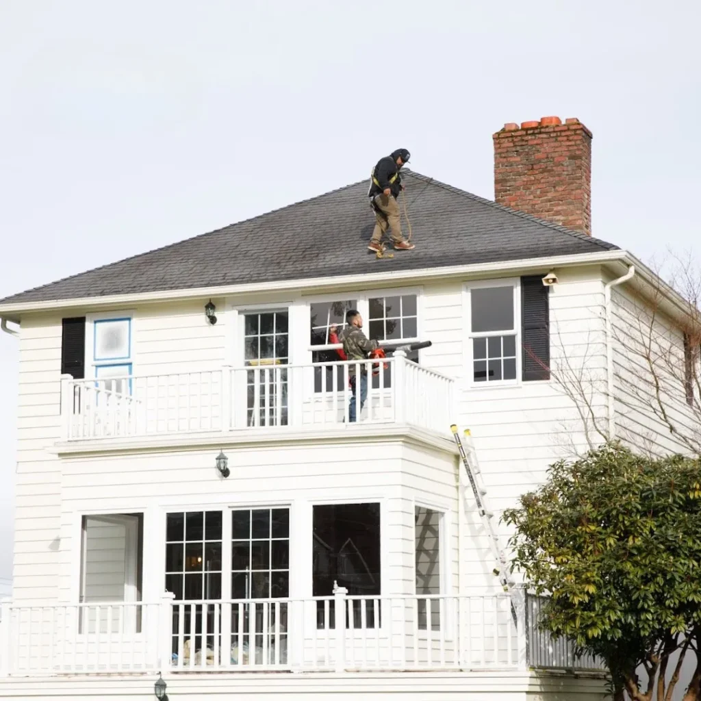 Workers repairing a house roof