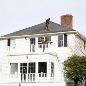 Workers repairing a house roof